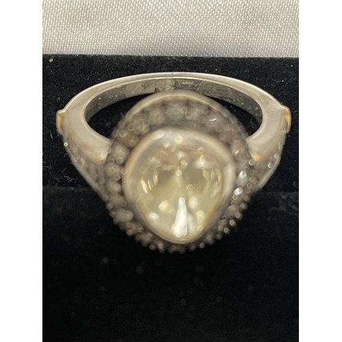 570 - A CONTINENTAL WHITE AND YELLOW METAL RING WITH CENTRE DIAMOND AND SMALLER SURROUNDING DIAMONDS WHICH... 