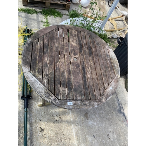 1734 - A ROUND WOODEN GARDEN TABLE AND A WASHING LINE