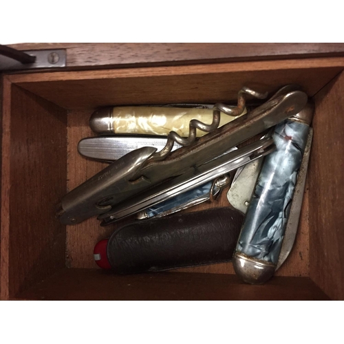 129 - A WOODEN BOX HOLDING SEVERAL SMALL POCKET KNIVES AND LIGHTERS AND AN 'ARISTON' CLOUDISER