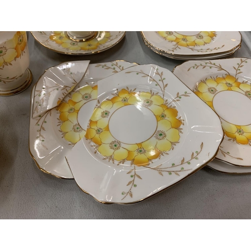 182 - AN COLLECTION OF ROSLYN FINE BONE CHINA IN A YELLOW FLORAL PATTERN WITH GOLD ACCENTED EDGES