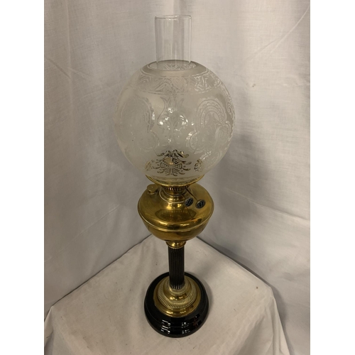 294 - A BRASS AND GLASS OIL LAMP ON A METAL BASE WITH A GLASS DECORATIVE SHADE   H: 69CM