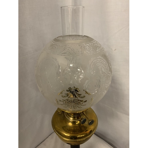 294 - A BRASS AND GLASS OIL LAMP ON A METAL BASE WITH A GLASS DECORATIVE SHADE   H: 69CM