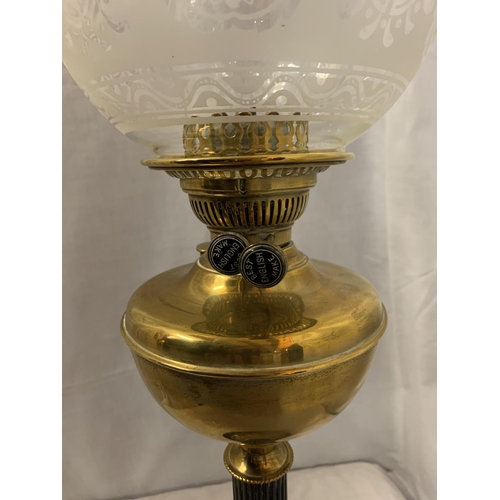 294 - A BRASS AND GLASS OIL LAMP ON A METAL BASE WITH A GLASS DECORATIVE SHADE   H: 69CM