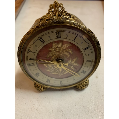 36 - A VINTAGE ORNATE GILT ALARM CLOCK WITH EMBRIODERED FACE