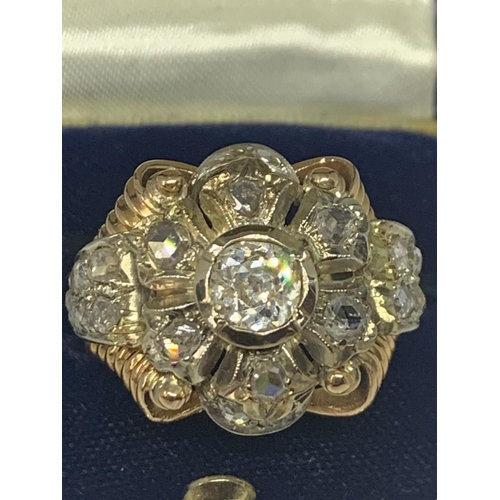 605 - AN 18 CARAT WHITE AND YELLOW GOLD ART DECO CLUSTER RING WITH A CENTRE DIAMOND, SIX SURROUNDING DIAMO... 