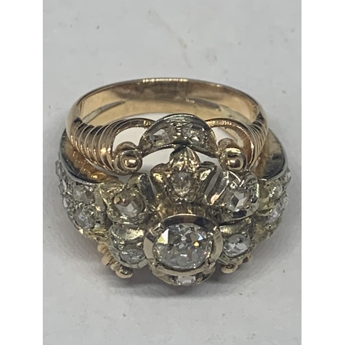 605 - AN 18 CARAT WHITE AND YELLOW GOLD ART DECO CLUSTER RING WITH A CENTRE DIAMOND, SIX SURROUNDING DIAMO... 