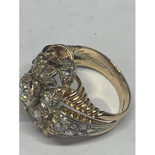 605 - AN 18 CARAT WHITE AND YELLOW GOLD ART DECO CLUSTER RING WITH A CENTRE DIAMOND, SIX SURROUNDING DIAMO... 