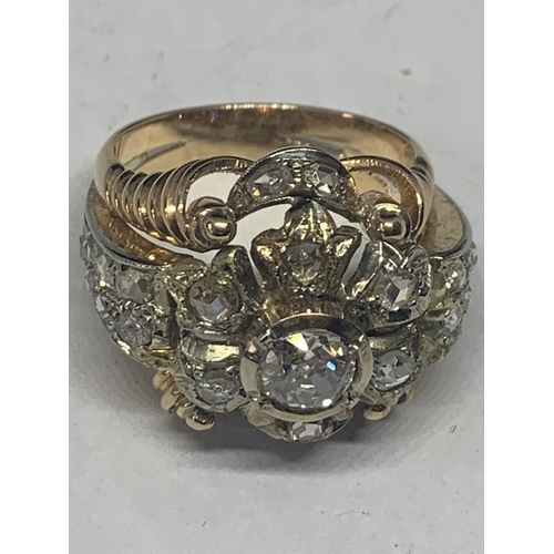 605 - AN 18 CARAT WHITE AND YELLOW GOLD ART DECO CLUSTER RING WITH A CENTRE DIAMOND, SIX SURROUNDING DIAMO... 