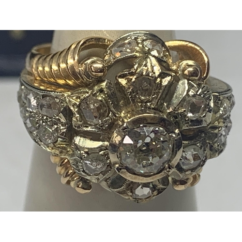 605 - AN 18 CARAT WHITE AND YELLOW GOLD ART DECO CLUSTER RING WITH A CENTRE DIAMOND, SIX SURROUNDING DIAMO... 