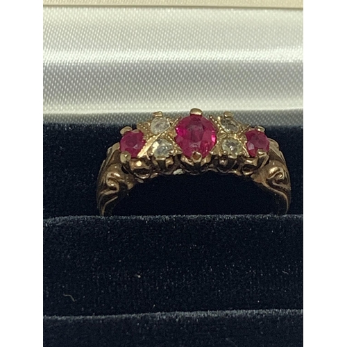 674 - A 9 CARAT GOLD RING WITH THREE IN LINE RUBYS AND FOUR DIAMONDS SIZE P WITH A PRESENTATION BOX