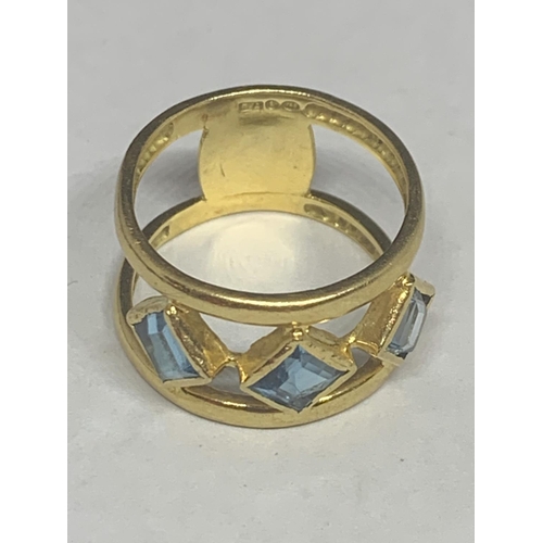 679 - AN 18 CARAT GOLD RING WITH THREE LOZENGE BLUE STONES BELIEVED AQUAMARINE ON A DOUBLE BAR