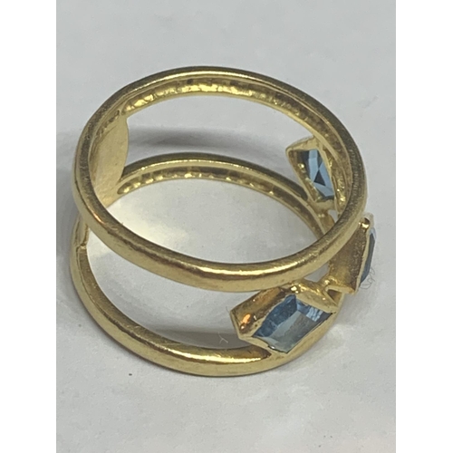 679 - AN 18 CARAT GOLD RING WITH THREE LOZENGE BLUE STONES BELIEVED AQUAMARINE ON A DOUBLE BAR