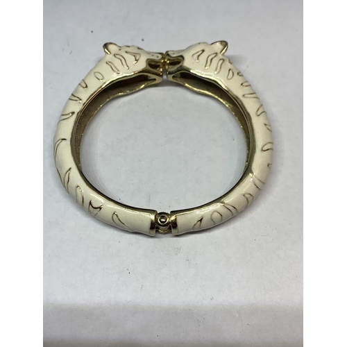 569 - A SUSAN CAPLIN TIGER BANGLE IN CREAM AND YELLOW METAL WITH A PRESENTATION BOX