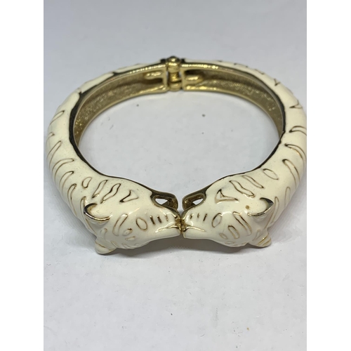 569 - A SUSAN CAPLIN TIGER BANGLE IN CREAM AND YELLOW METAL WITH A PRESENTATION BOX