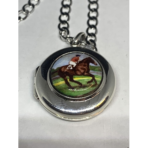 543 - A SILVER CHAIN AND LOCKET WITH AN ENAMEL RACE HORSE AND RIDER DESIGN