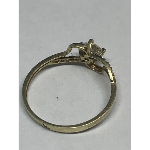 547 - A 9 CARAT GOLD TWIST STYLE RING WITH CENTRE CLEAR STONE AND CHIP SHOULDERS