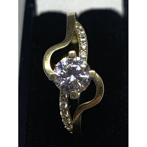 547 - A 9 CARAT GOLD TWIST STYLE RING WITH CENTRE CLEAR STONE AND CHIP SHOULDERS