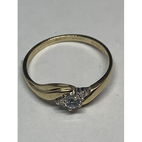 586 - A 9 CARAT GOLD RING ON TWIST DESIGN WITH CLEAR STONES IN A PRESENTATION BOX