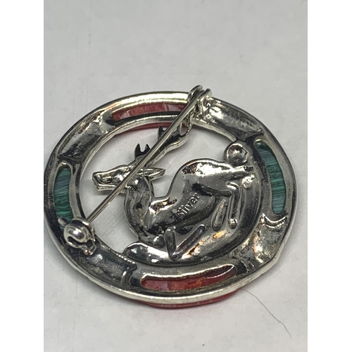 597 - A MARKED SILVER BROOCH WITH RED AND GREEN STONES SURROUNDING A CENTRAL STAG DESIGN