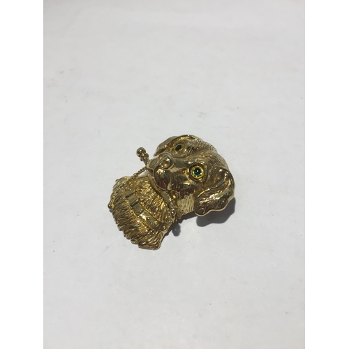 613 - A SILVER GILT PENDANT IN THE FORM OF A DOG WITH GLASS EYES