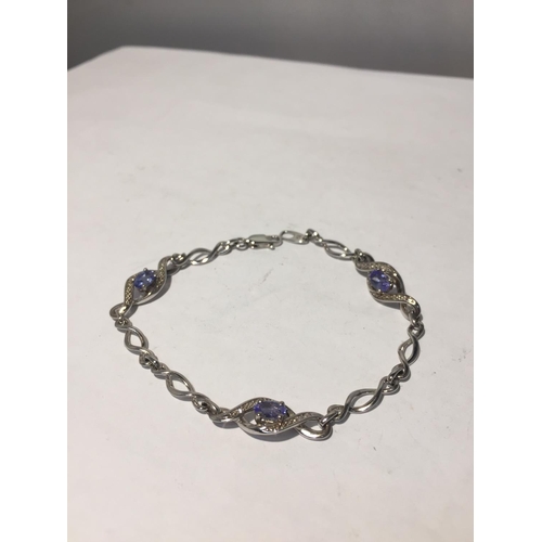 621 - A SILVER BRACELET WITH POSSIBLY AQUAMARINES AND DIAMOND CHIPS