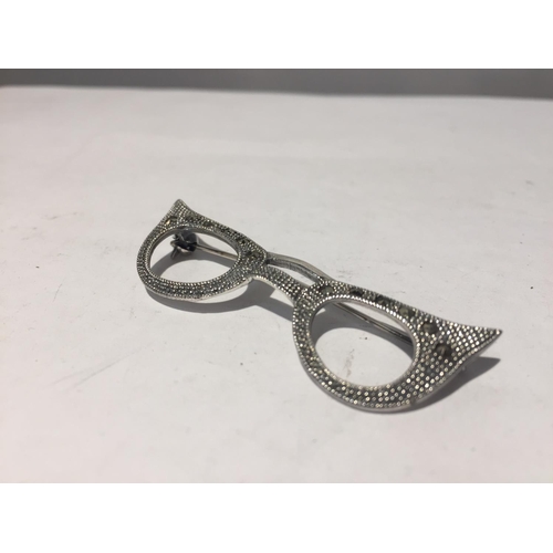 625 - A MARKED SILVER BROOCH IN THE FORM OF A PAIR OF GLASSES WITH CLEAR STONES AND CHIPS