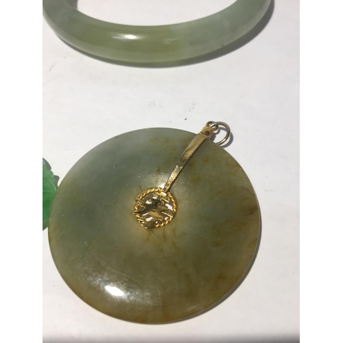 628 - FOUR VARIOUS PIECES OF JADE TO INCLUDE A BANGLE AND THREE PENDANTS