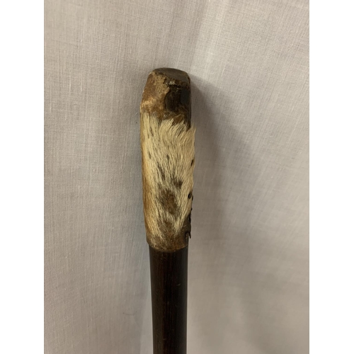 123 - AN AFRICAN TRIBAL STICK WITH ANIMAL SKIN HANDLE