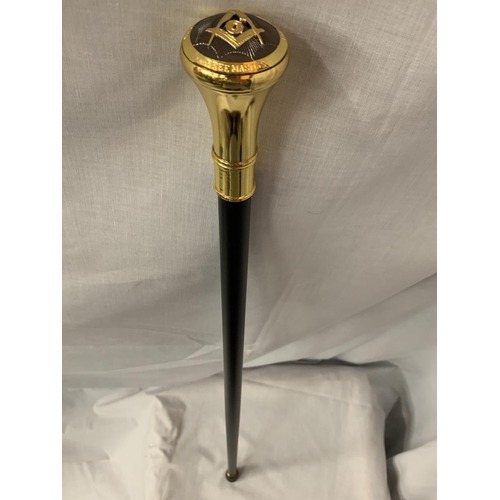 24 - A BLACK WALKING STICK WITH A YELLOW METAL MASONIC TOP