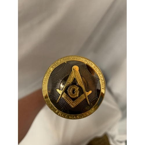 24 - A BLACK WALKING STICK WITH A YELLOW METAL MASONIC TOP