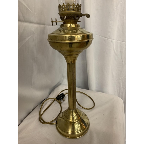 52 - A BRASS COLUMN OIL LAMP WITH GLASS CHIMNEY H:47CM INC. CHIMNEY 69CM (BEEN CONVERTED TO ELECTRIC)