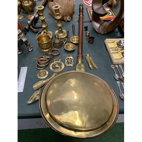 55 - A COLLECTION OF BRASS WARE TO INCLUDE WARMING PAN, CANDLESTICKS, HORSE BRASSES ETC