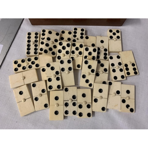 57 - A WOODEN BOXED SET OF BONE DOMINOES