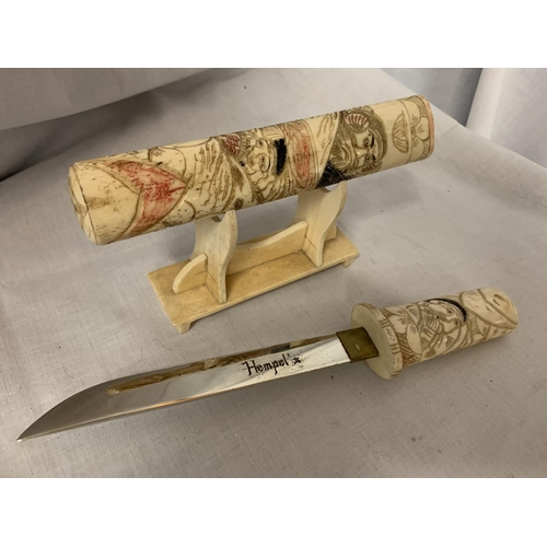 82 - A DECORATIVE BONE 'HEMPEL'S' LETTER OPENER ON STAND DEPICTING ORIENTAL STYLE SCENES