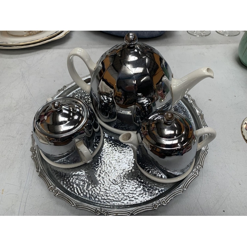 152A - A RETRO STYLE SILVER PLATED AND CERAMIC TEAPOT, JUG AND SUGAR BOWL ON A PLATED TRAY