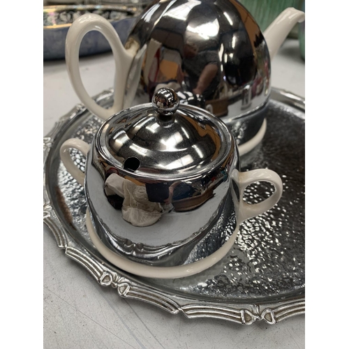 152A - A RETRO STYLE SILVER PLATED AND CERAMIC TEAPOT, JUG AND SUGAR BOWL ON A PLATED TRAY