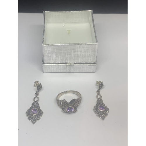522 - A SILVER MARCASITE RING WITH PURPLE CENTRE STONE AND A PAIR OF MATCHING EARRINGS IN A PRESENTATION B... 