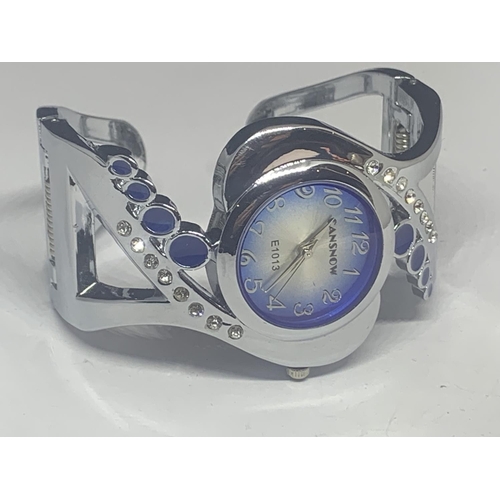 538 - A CANSOW FASHION WATCH ON A WHITE METAL A BANGLE STRAP WITH CLEAR AND BLUE STONE DECORATION SEEN WOR... 