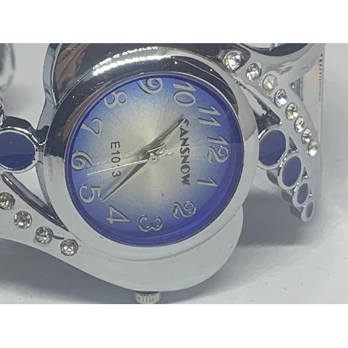 538 - A CANSOW FASHION WATCH ON A WHITE METAL A BANGLE STRAP WITH CLEAR AND BLUE STONE DECORATION SEEN WOR... 