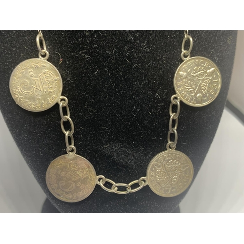 575 - A SILVER NECKLACE WITH FOUR THREE PENCE COINS ON A BLACK DISPLAY BUST