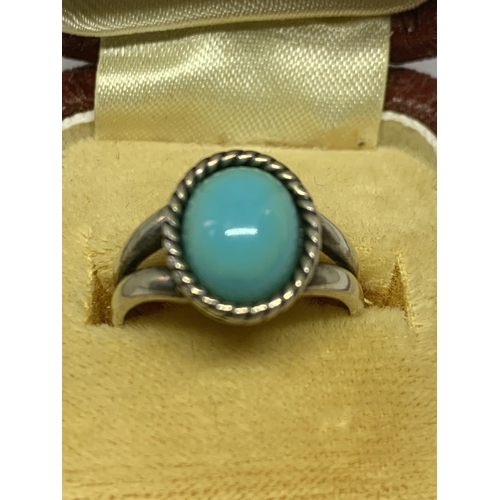 577 - A SILVER RING WITH AN OVAL BLUE NAVAJO STYLE STONE