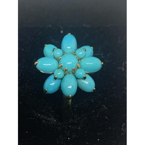 588 - A 9 CARAT GOLD RING WITH BLUE NAVAJO STYLE STONES IN A FLOWER DESIGN WITH A PRESENTATION BOX