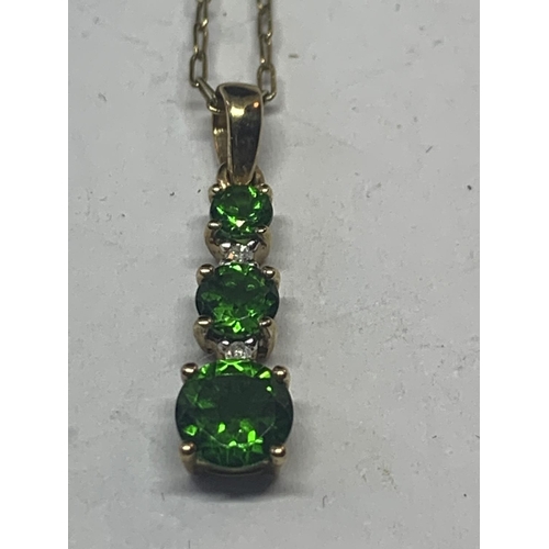 593 - A 9 CARAT GOLD NECKLACE WITH A THREE IN LINE GREEN STONE PENDANT