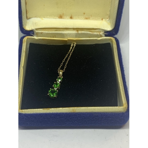 593 - A 9 CARAT GOLD NECKLACE WITH A THREE IN LINE GREEN STONE PENDANT