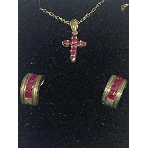 597 - A SILVER NECKLACE WITH A RUBY CROSS PENDANT AND A PAIR OF MATCHING EARRINGS IN A PRESENTATION BOX