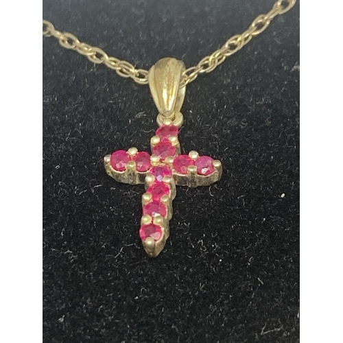 597 - A SILVER NECKLACE WITH A RUBY CROSS PENDANT AND A PAIR OF MATCHING EARRINGS IN A PRESENTATION BOX