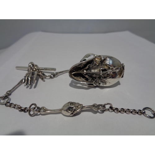 610 - A HEAVY SILVER ALBERT CHAIN WITH LARGE SKULL FOB AND BONE, HAND ETC DESIGN