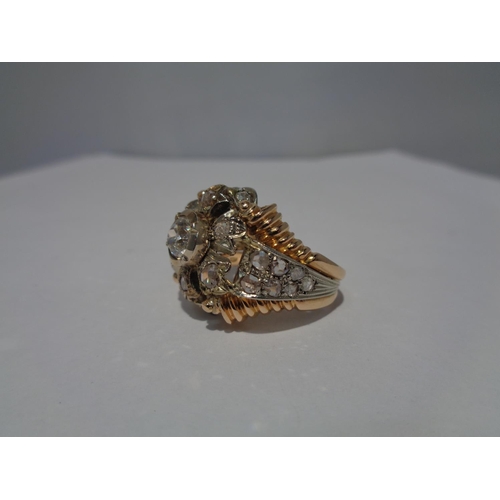 612 - AN 18 CARAT WHITE AND YELLOW GOLD ART DECO CLUSTER RING WITH A CENTRE DIAMOND, SIX SURROUNDING DIAMO... 