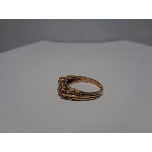 614 - A 9 CARAT GOLD RING WITH THREE IN LINE RUBYS AND FOUR DIAMONDS SIZE P WITH A PRESENTATION BOX