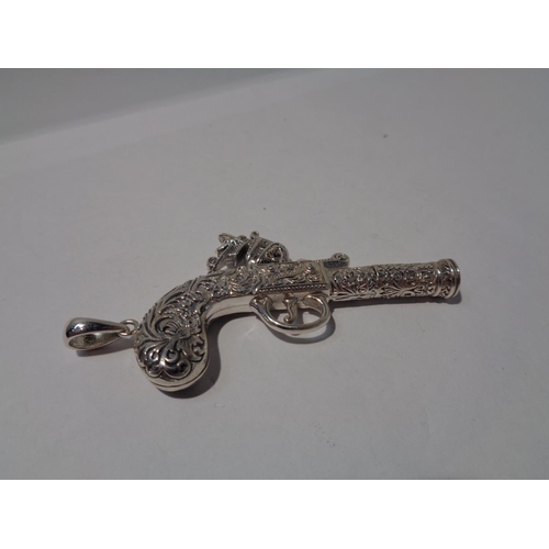 643 - A PENDANT IN THE FORM OF AN ORNATE PISTOL